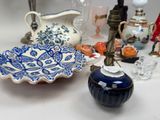 a blue and white bowl sitting on a table next to a candle