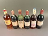 six bottles of wine lined up in a row on a table