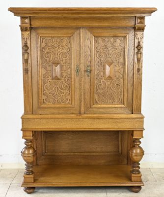 une vieille armoire en bois avec des sculptures sur les portes et une étagère