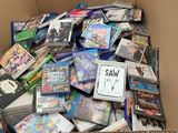 a cardboard box full of dvds and games for sale