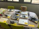 many laptops on the table with wires all over them