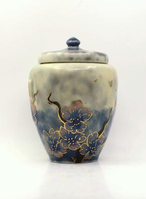 a blue and white vase with a lid on a white surface