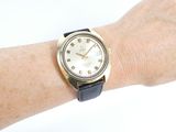 a wrist with a watch on it that has roman numerals on it