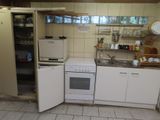 une petite cuisine équipée d'un réfrigérateur, d'une cuisinière et d'un évier