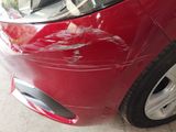 a close up of a red car that has been dented