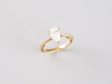 a gold engagement ring with a pear shaped diamond