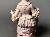 figurine of a woman with a basket of flowers in her hand