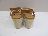 beige wedged sandals with braid straps on a white surface