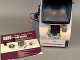 une vieille photo d'une petite machine avec un CD posé devant