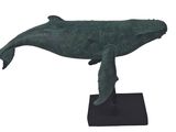 statue of a humpback whale on a black base on a white background