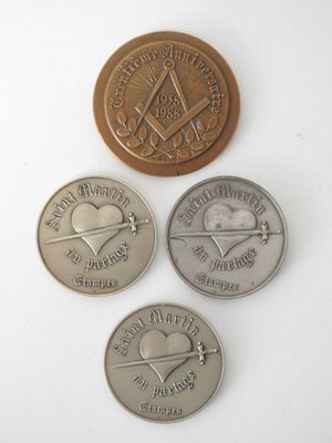 Quatre pièces différentes sont représentées sur une surface blanche ; l'une a la forme d'un cœur et l'autre celle d'un compas.