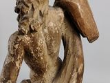 statue of a man holding a surfboard on a wooden base