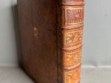 an old book sitting on top of a table next to a wall