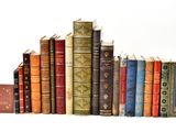 many old books lined up on a white surface