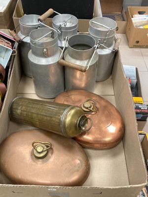 une boîte remplie de casseroles et de poêles en cuivre posée sur une table