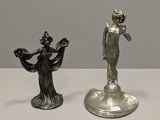 pair of silver figurines of a woman and a man on a pedestal