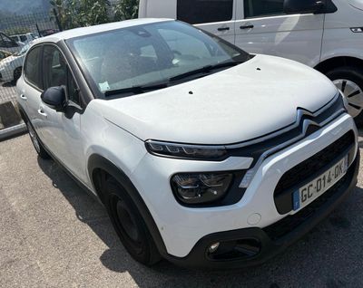 une Citroën blanche garée sur un parking à côté d'une camionnette blanche