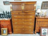 une commode et une armoire dans une pièce où sont accrochés des tableaux au mur