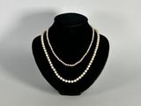 un collier de perles blanches sur un mannequin noir