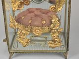 a glass case with a gold decoration on the inside of it