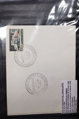 une enveloppe sur laquelle sont collés deux timbres, posée sur une feuille de papier