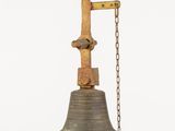an old metal bell hanging from a chain on a white background