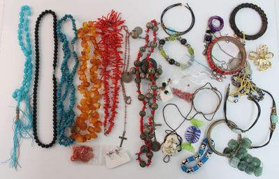 many different necklaces and bracelets laid out on a table