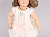 a doll that is wearing a white dress and white shoes