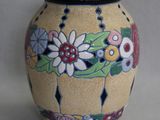 un vase orné d'un motif floral, posé sur une table