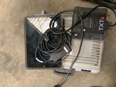 un ordinateur portable et un chargeur posés par terre