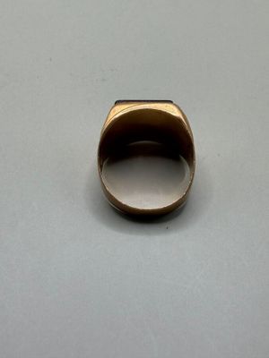 a close up of a gold ring on a white surface