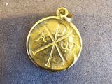 une médaille d'or posée sur un oreiller posé par terre