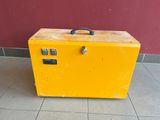 a yellow suitcase sitting on the floor in front of a red wall