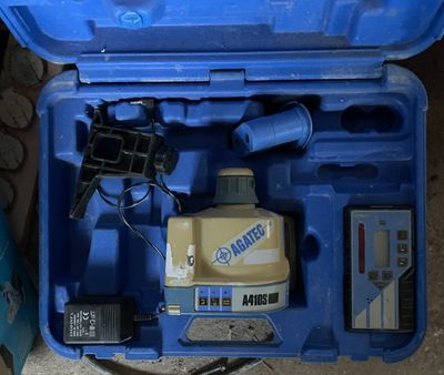 une mallette bleue contenant des outils, posée par terre