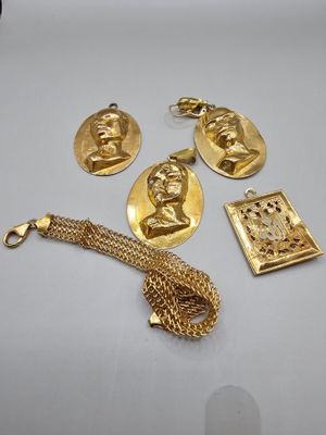 three gold - plated items including a necklace, bracelet, and pendant