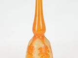 an orange glass vase with a flower design on it