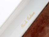 the back of a brown and white purse with gold lettering on it