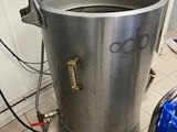 a large metal pot with a handle on the floor