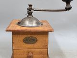 an old coffee grinder with a wooden base and a metal handle