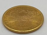 l'image d'une pièce d'or posée sur une surface blanche