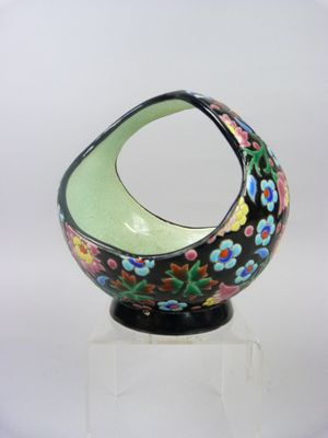black and green vase with flowers on it on a clear base