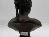 a bronze bust of a woman with a bun on her head