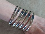 a close up of a person ' s hand with a silver bracelet