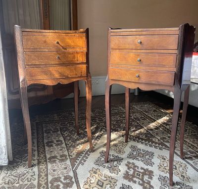 two wooden chairs sitting next to each other on a rug