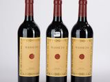 trois bouteilles de vin rouge posées côte à côte sur une table