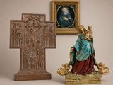 une statue représentant une femme tenant un bébé dans ses bras, à côté d'une croix