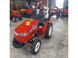 a red tractor parked in a warehouse with other tractors in the background