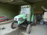 un tracteur vert garé dans un garage