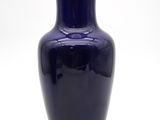 un vase bleu bordé d'or sur fond blanc