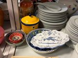 many plates and bowls on the counter in the store